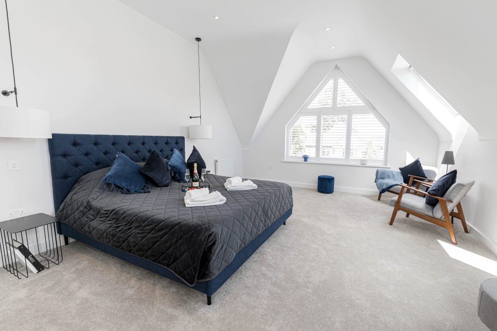 Spacious white bedroom with sloped ceiling