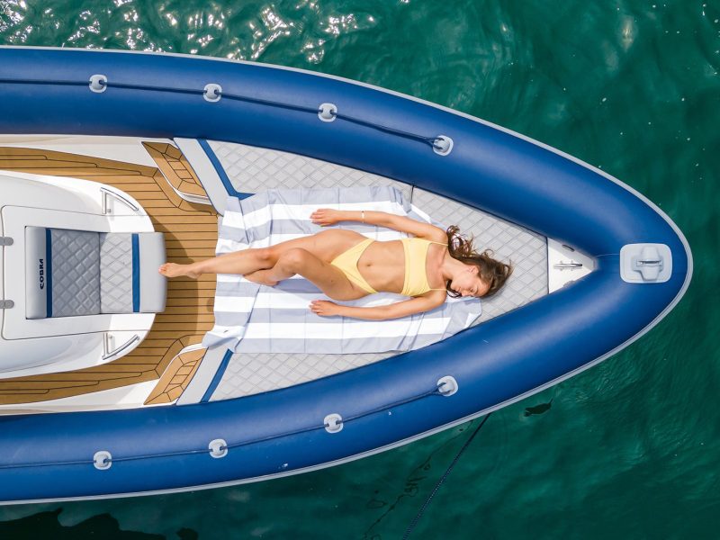 Young model sunbathing on deck of boat