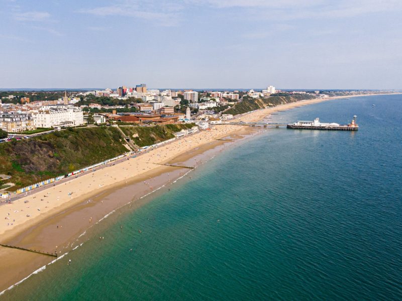 Sand beach with blue seas and pier